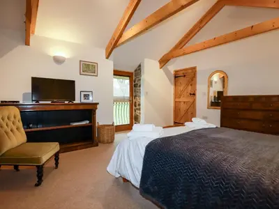 a bedroom with two beds and a flat screen tv at The Orchard in Bodmin