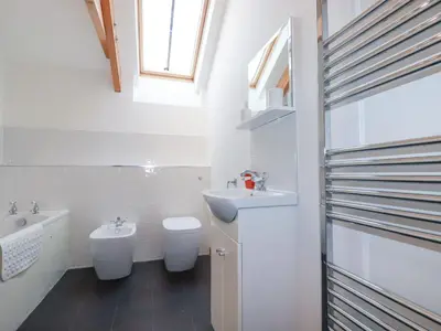 a white bathroom with a sink and a toilet at The Orchard in Bodmin