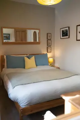 a bedroom with a large bed with a yellow pillow at Breathtaking Harbourside Views With Parking at 'Harbour Strand' in Falmouth