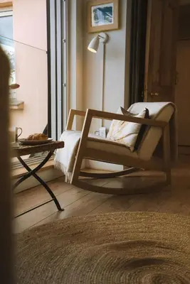 a living room with a chair and a table at Breathtaking Harbourside Views With Parking at 'Harbour Strand' in Falmouth