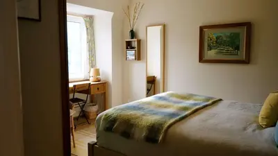 a bedroom with a bed and a desk and a window at Breathtaking Harbourside Views With Parking at 'Harbour Strand' in Falmouth