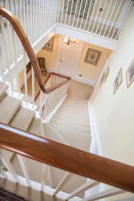 a winding staircase in a home with white railings at The Vean in Mevagissey