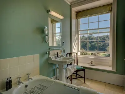 a bathroom with a tub and a sink and a window at The Vean in Mevagissey