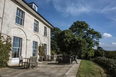 a patio with chairs and a table in front of a building at The Vean in Mevagissey