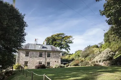 an old stone house on a green lawn at The Vean in Mevagissey