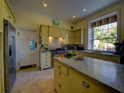 a large kitchen with yellow cabinets and a counter top at The Vean in Mevagissey