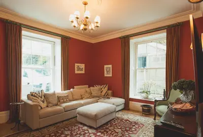 a living room with a couch and two windows at The Vean in Mevagissey