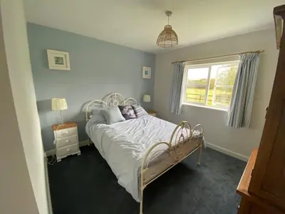 a bedroom with a bed and a window at Seahorse Cottage in Helston