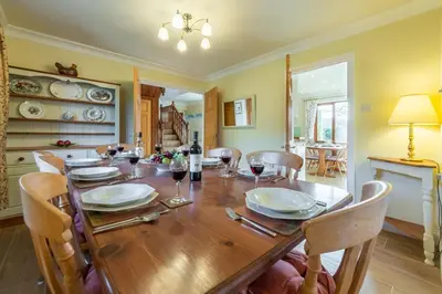 a dining room with a wooden table and chairs at April Cottage in Polzeath