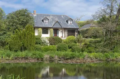 a house with a pond in front of it at April Cottage in Polzeath