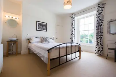a bedroom with a bed and a window at Captain's House Falmouth in Falmouth