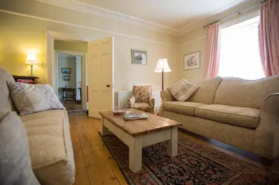 a living room with a couch and a coffee table at Captain's House Falmouth in Falmouth