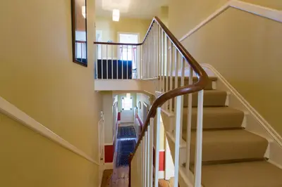 a staircase in a home with white railings at Captain's House Falmouth in Falmouth