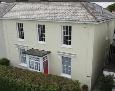 a white house with a red door at Captain's House Falmouth in Falmouth