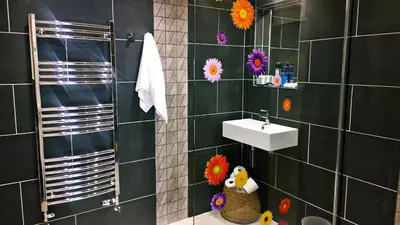 a bathroom with a sink and flowers on the wall at Quay Street in Lostwithiel