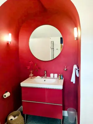 a red bathroom with a sink and a mirror at Quay Street in Lostwithiel
