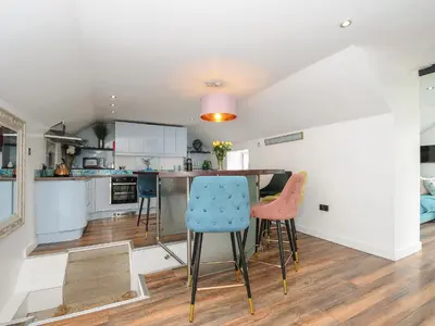 a kitchen with a table and chairs in a room at Moon's Cottage in Fowey
