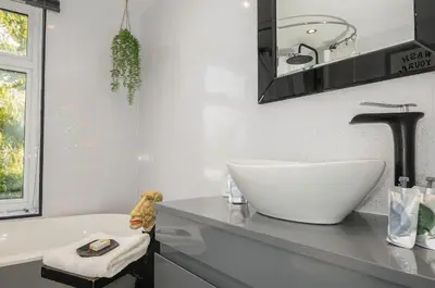 a bathroom with a sink and a bath tub at Moon's Cottage in Fowey