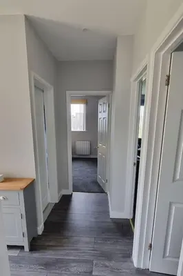 a hallway of a room with white walls and doors at Cornish Village Getaway in Gwennap
