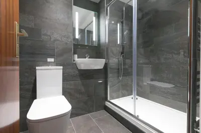 a bathroom with a toilet and a shower and a sink at 28 Carrack Widden in St Ives