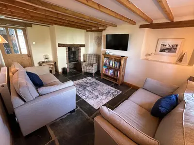a living room with two couches and a tv at Stable Door Cottage in Newquay