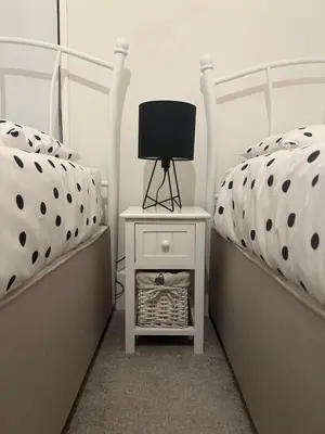 a bedroom with two beds and a table with a lamp at Stable Door Cottage in Newquay
