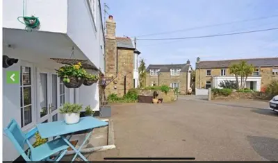 a blue table and chairs outside of a house at Stable Door Cottage in Newquay