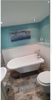 a bathroom with a white tub and a toilet at Stable Door Cottage in Newquay