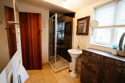 a bathroom with a shower and a sink and a toilet at Roses Cottage in Porthscatho