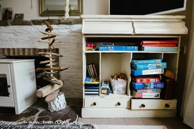 a room with a book shelf with books at Roses Cottage in Porthscatho