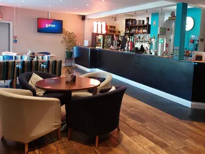a restaurant with a table and chairs and a bar at 78 Atlantic Reach in Newquay
