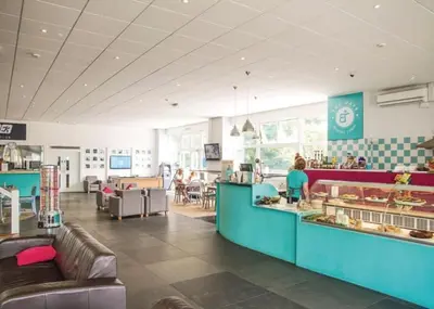 a restaurant with a counter and people sitting at tables at 78 Atlantic Reach in Newquay
