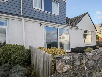 a house with a stone fence in front of it at Waverley in St Austell