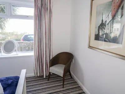 a chair sitting in a room next to a window at Waverley in St Austell