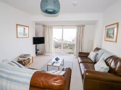 a living room with a leather couch and a tv at Waverley in St Austell