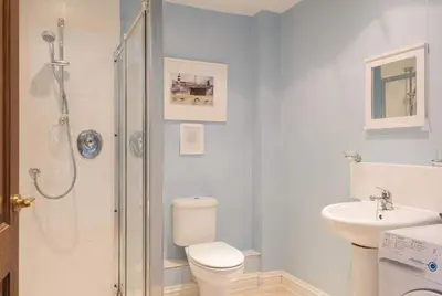 a bathroom with a shower and a toilet and a sink at Cosy Beachfront Retreat with Stunning Sea Views & Free Access to a Local Indoor Pool in Talland