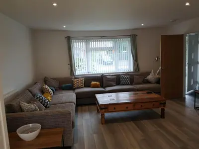 a living room with a couch and a coffee table at Cornish Coastal Bungalow in Padstow