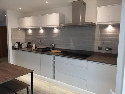 a kitchen with white cabinets and a counter top at Cornish Coastal Bungalow in Padstow