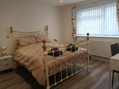 a bedroom with a bed with a metal frame at Cornish Coastal Bungalow in Padstow