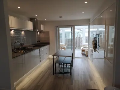 a kitchen with a table and a dining room at Cornish Coastal Bungalow in Padstow