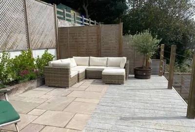 a patio with a white couch on a patio at Mesmerising sea views - Penrose - above the beach Cornwall. in Downderry