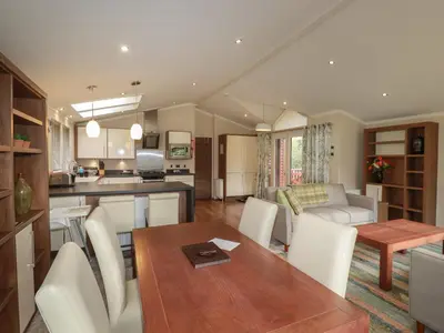 a kitchen and living room with a table and chairs at Haven Lodge in Tintagel