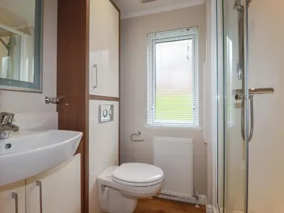 a bathroom with a toilet and a sink at Haven Lodge in Tintagel