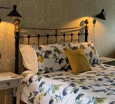 a bed with a bunch of pillows on it at Treveighan Farmhouse in Saint Teath