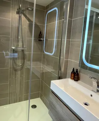 a bathroom with a shower and a sink at Treveighan Farmhouse in Saint Teath