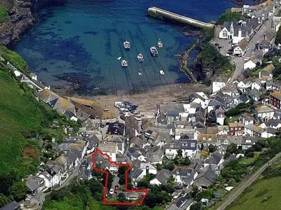 an aerial view of a town with boats in the water at The Sail Loft (part of Manor House) in Port Isaac