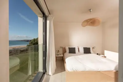 a bedroom with a bed and a view of the ocean at Little Cottage and Love Shack in Praa Sands