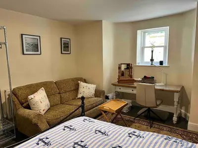 a living room with a couch and a desk at The Hive in St Austell