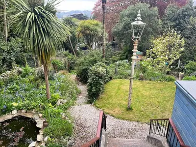 a garden with a bench and a street light at The Hive in St Austell