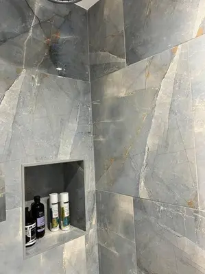 a bathroom with a shelf with bottles on it at The Hive in St Austell
